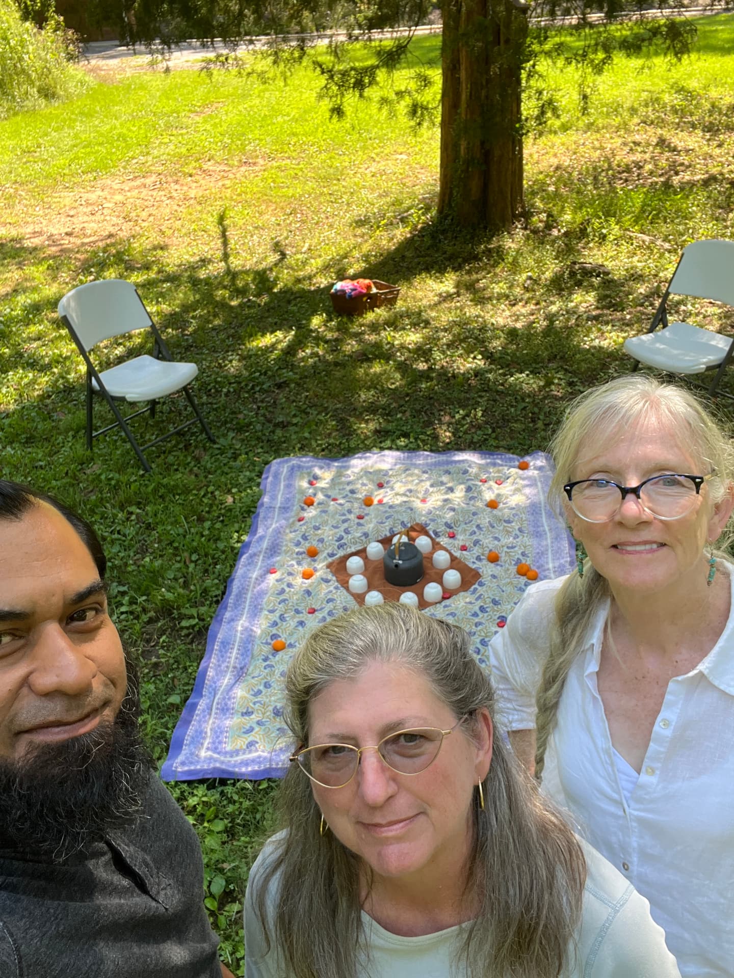 Sanare.earth guides Joel Cruz, Anne Bailey and Janice Barrett together at a tea circle in the woods
